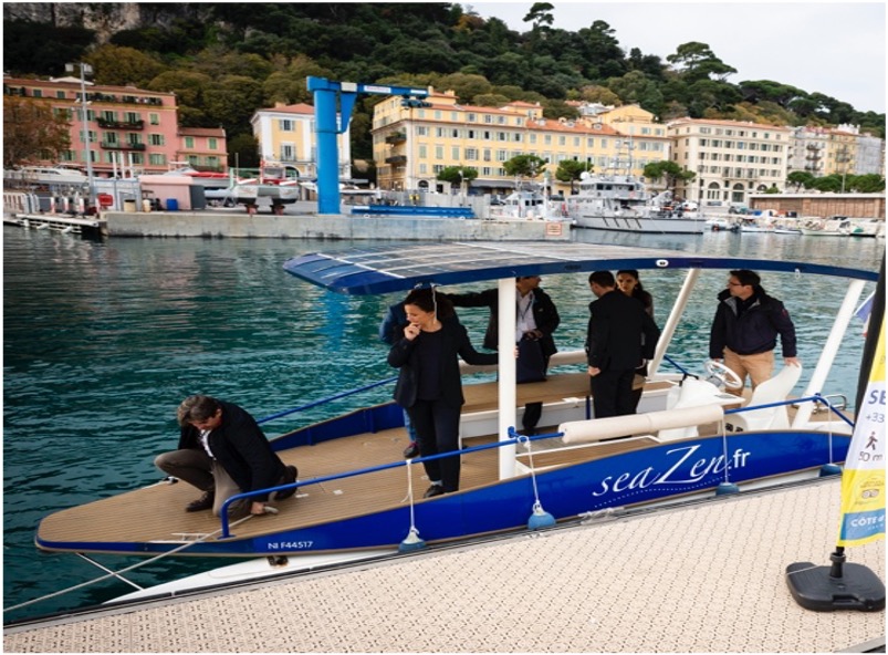 People on a blue boat docked at a marina with colorful buildings in the background.