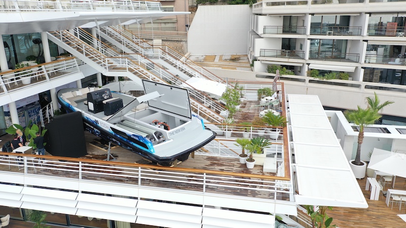 Boat displayed on terrace of modern multi-level building with railings.