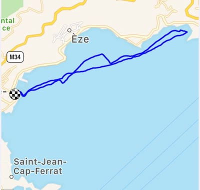 A map showing a blue path along the coastline near Èze, with a checkered flag marking the starting point.