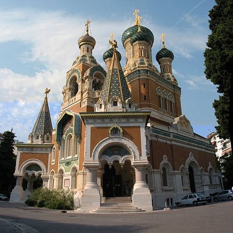 Ornate church with green onion domes and intricate architecture.