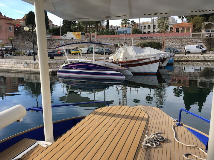 Boats docked in a marina with reflections on the water.