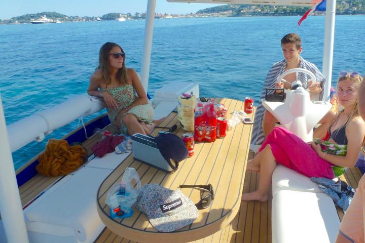 People relaxing on a boat with snacks and drinks on a sunny day.