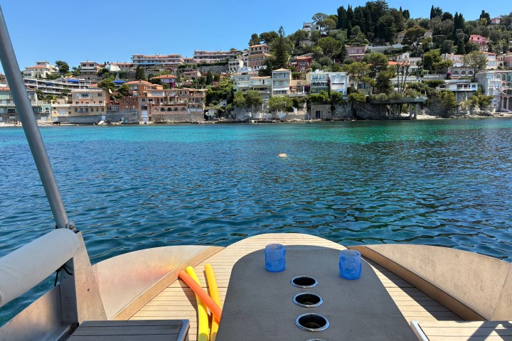 View from a boat towards a coastal town with houses by a blue sea.