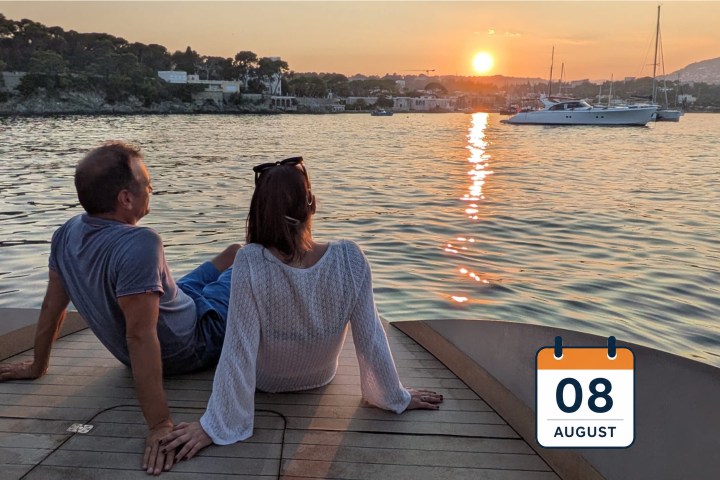 Two people relaxing on a boat at sunset, with a calendar icon showing August 8.